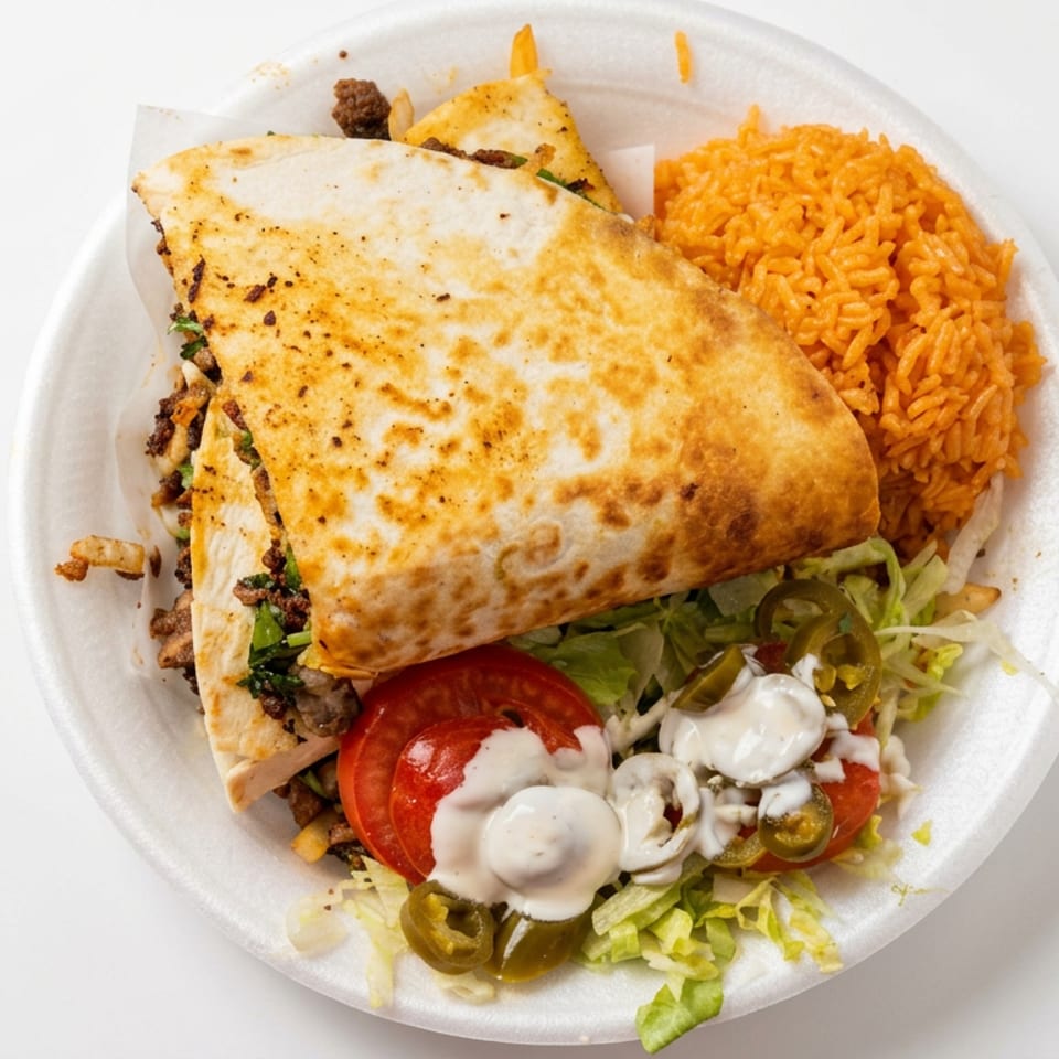 A toasted stuffed quesadilla with seasoned meat, lettuce, tomato, jalapeños, creamy sauce, and orange rice on a plate.